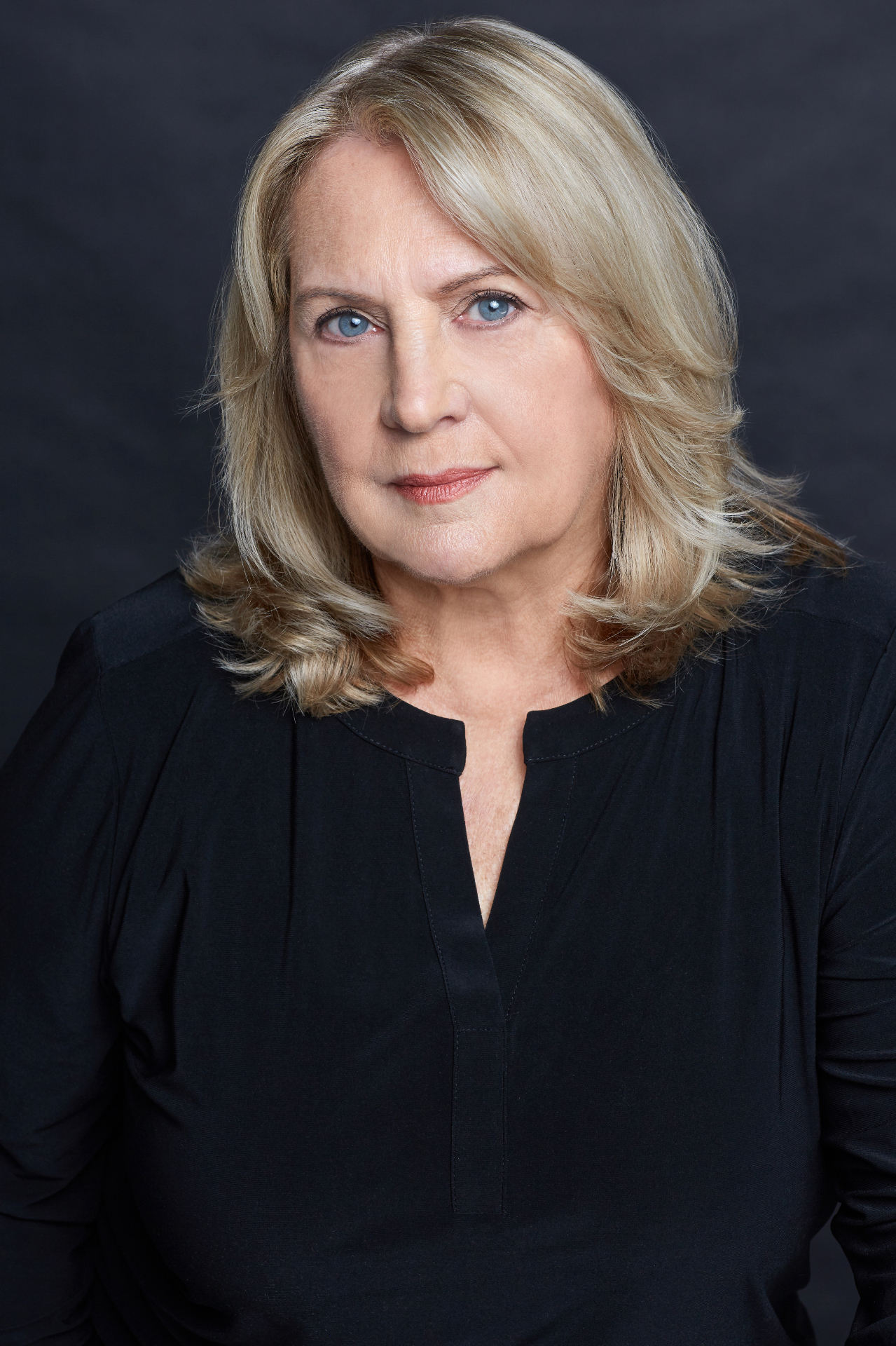 Cookie Colletti actor headshot in black top with dark background